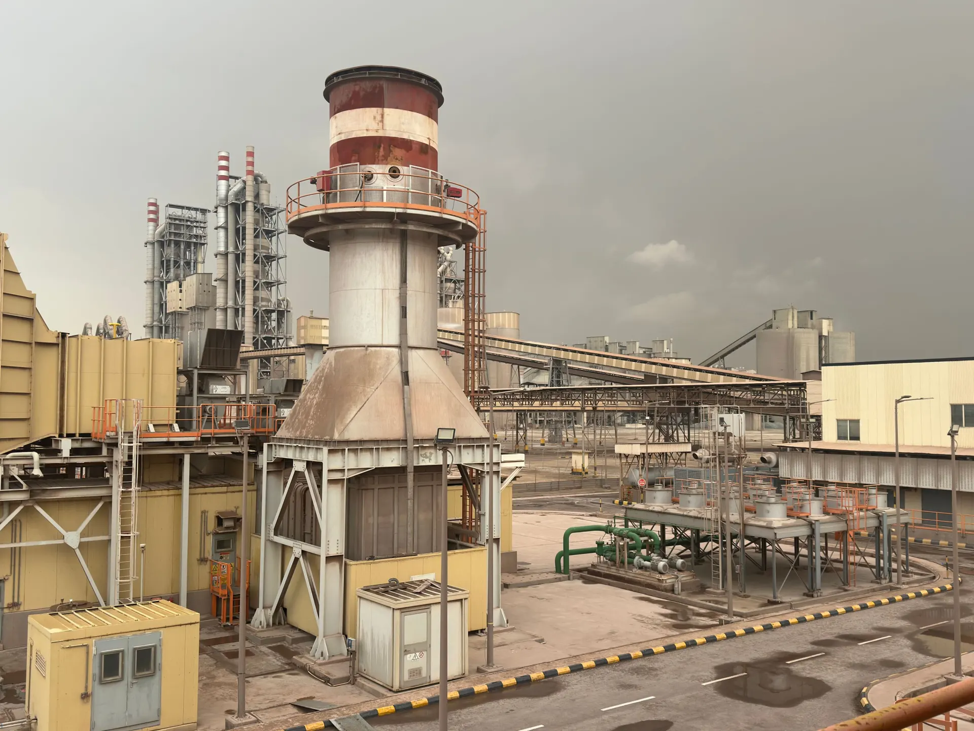 Industrial plant with an exhaust stack, conveyors and pipework in Saudi Arabia
